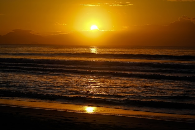 Prachtige zonsondergang op het strand aan de rand van het zand met een prachtige natuurachtergrond