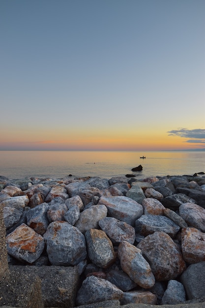 prachtige zonsondergang over de zee met frame van kleurrijke stenen