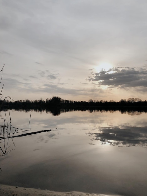 Prachtige zonsondergang over een herfstmeer en droge planten