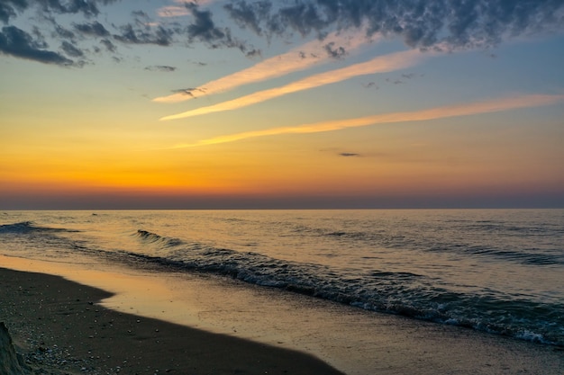 Prachtige zonsondergang over zee met weerspiegeling in water, majestueuze wolken aan de hemel