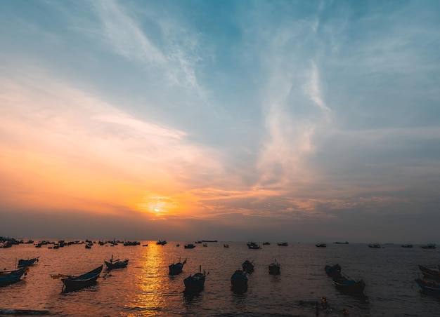 Prachtige zonsondergang Tropisch zeegezicht met een boot op zandstrand bij bewolkt