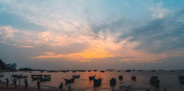 Prachtige zonsondergang Tropisch zeegezicht met een boot op zandstrand bij bewolkt