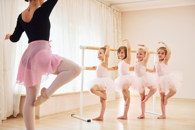 Practicing pose Little ballerinas preparing for performance