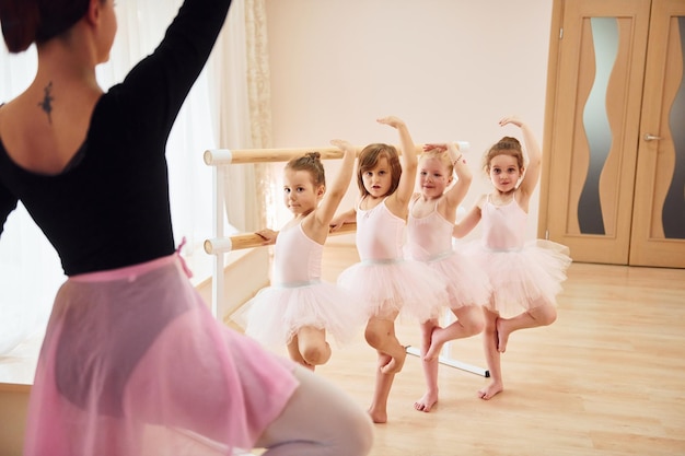 Practicing pose Little ballerinas preparing for performance