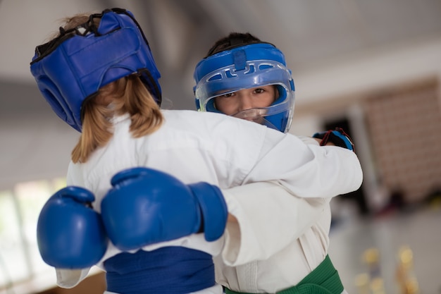 Practicing with girl. Dark-eyed boy wearing helmet and gloves practicing with girl wearing white kimono