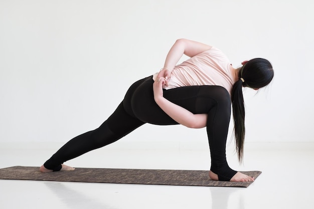 Photo practicing yoga in revolved bound side angle exercise parivrtta parsvakonasana