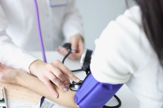 Practitioner taking blood pressure of woman