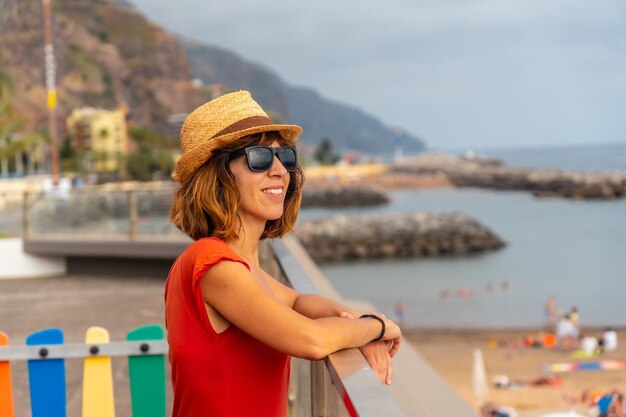 Praia da Calheta in de zomer jong toeristenmeisje in rode jurk op het strand Madeira Portugal