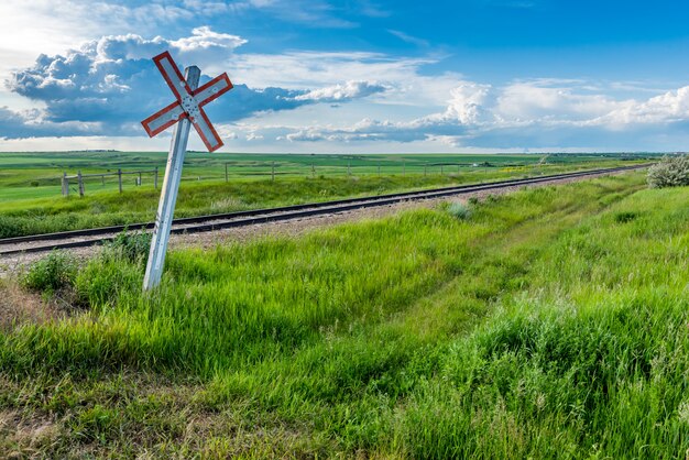 Prairiespoorwegteken en sporen met onweerswolken aan de horizon in Saskatchewan, Canada