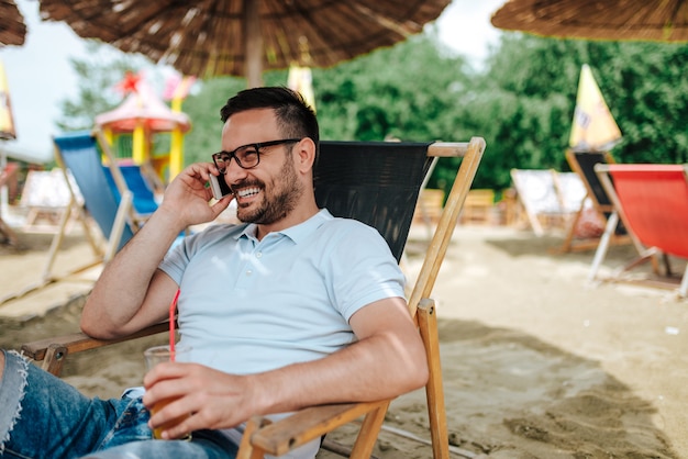 Praten aan de telefoon op het strand. Detailopname.