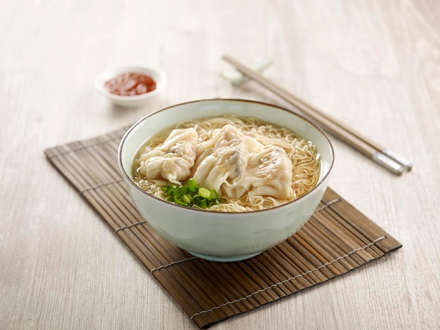 Prawn Dumpling Noodle with chopsticks served in a bowl isolated on mat side view on grey background