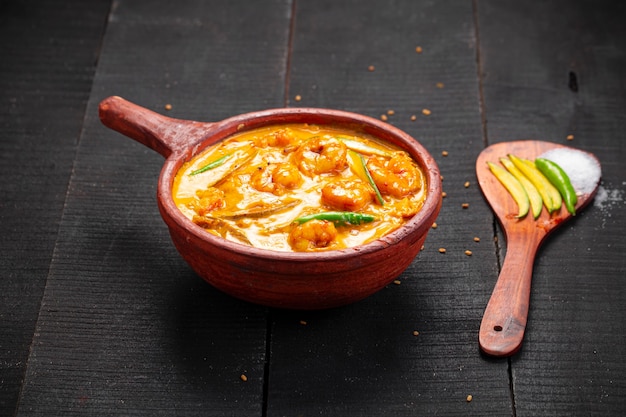 Foto gamberi al curry di mango piatto tradizionale del kerala realizzato con mango crudo e disposto in un vasetto di terracotta