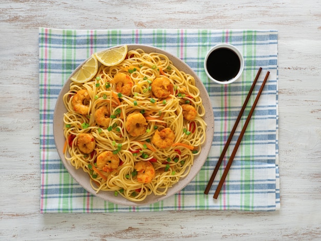 Photo prawn schezwan noodles with vegetables in a plate