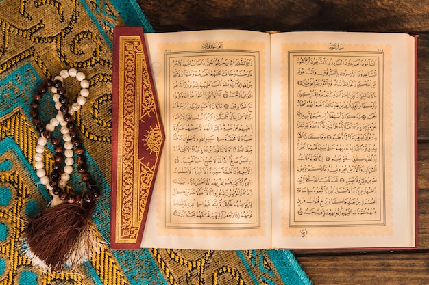 Prayer beads and Quran on mat