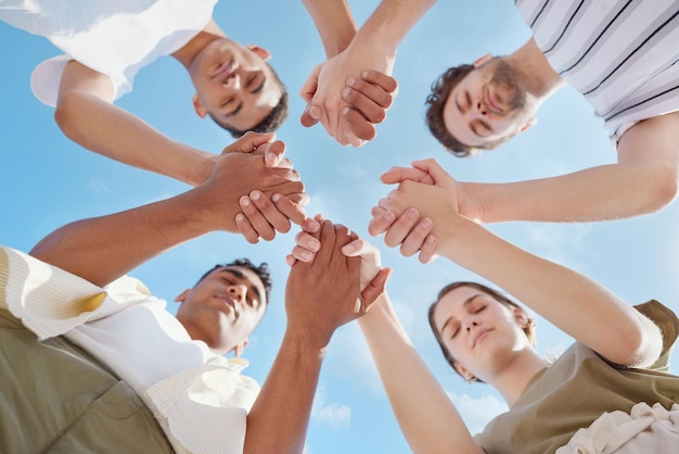 Prayer is the key to a successful day Shot of a group of young people holding hands while praying outside