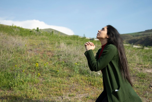 自然の中で祈る女性