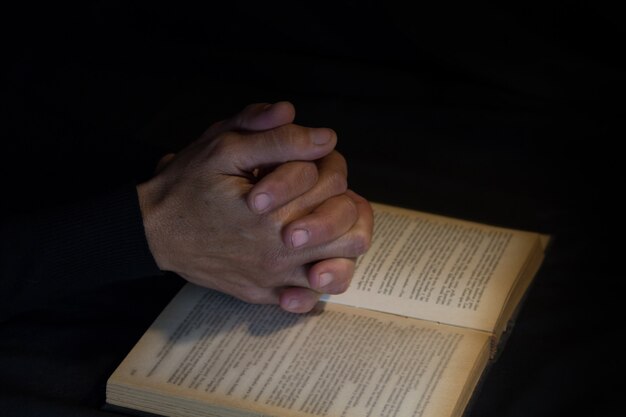 Praying hands on black background. faith and praise concept