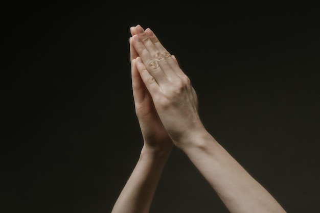 Photo praying hands to god in the dark. woman hands reaching out to god or for help in barokko style