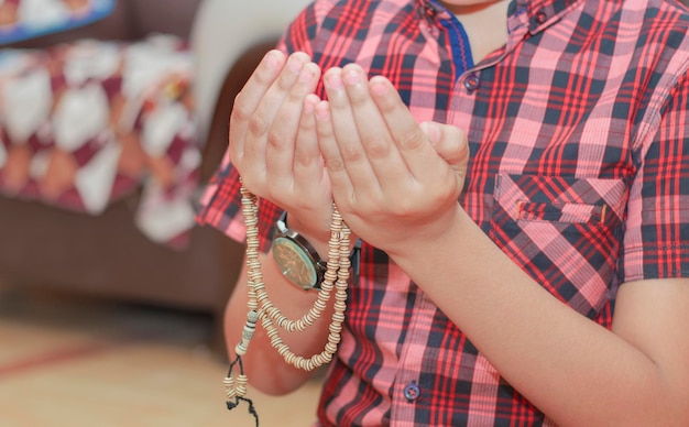 Foto bambino islamico in preghiera con battiti ragliantivista sfacciata del giovane ragazzo musulmano che prega con battiti