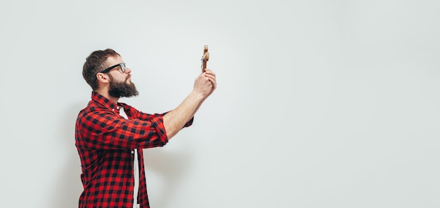 Praying religious man with a cross in his hands asks God for help during Covid coronavirus quarantine on a white background with an empty space for your text