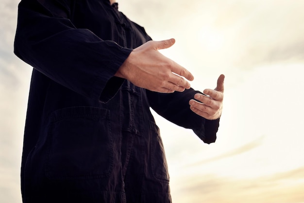 Foto pregare l'adorazione e l'uomo musulmano in natura per gratitudine, pace e fiducia in dio contro un cielo speranza islam e persona con le mani per una preghiera lode e fede islamica durante il ramadan e il tramonto