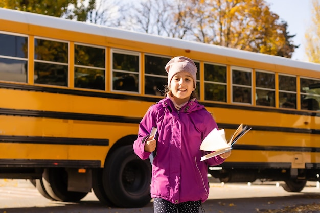 Pre teen girl getting on school bus.