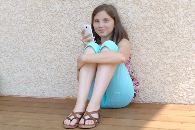 Фото Предварительно девушка подросток текстовых сообщений на мобильный телефон