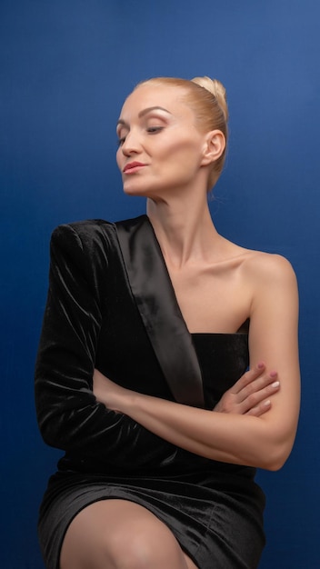 A predetermined older girl sits on a chair lovely in a tuxedo dress with a beautiful