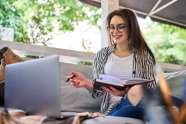 Preety vrouw die videogesprek thuis op de bank spreekt.