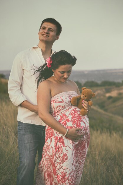 Pregnancy - a man and a pregnant woman hugging outdoors