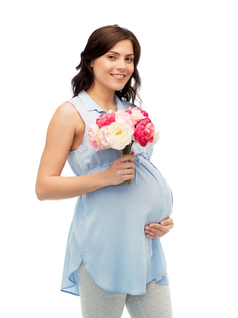 беременность, материнство, праздники, люди и концепция ожидания - счастливая беременная женщина с цветами, касающимися ее большого живота на белом фоне