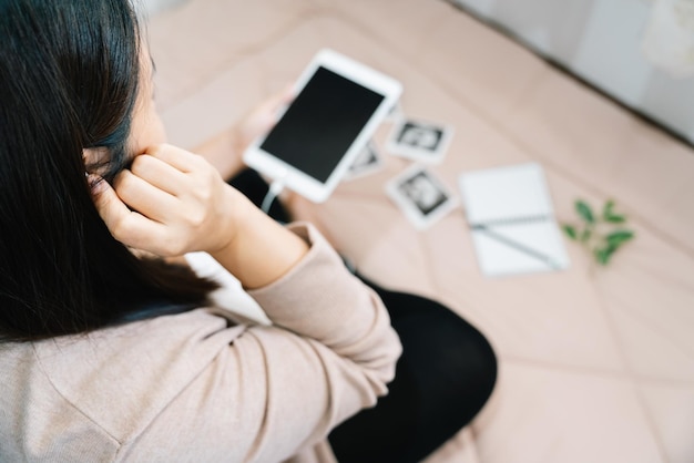 部屋にいる妊婦とヘッドホンの妊娠と音楽腹