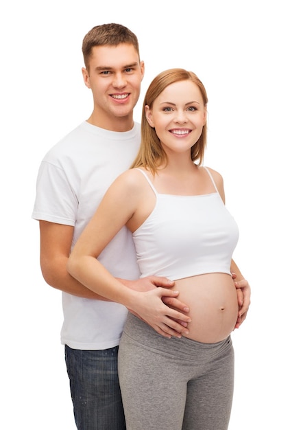 pregnancy, parenthood and happiness concept - happy young family expecting child