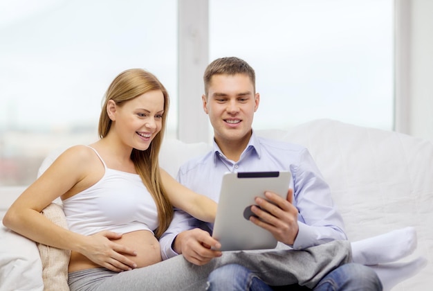 беременность, отцовство, интернет и технологическая концепция - ожидающая семья с планшетным компьютером