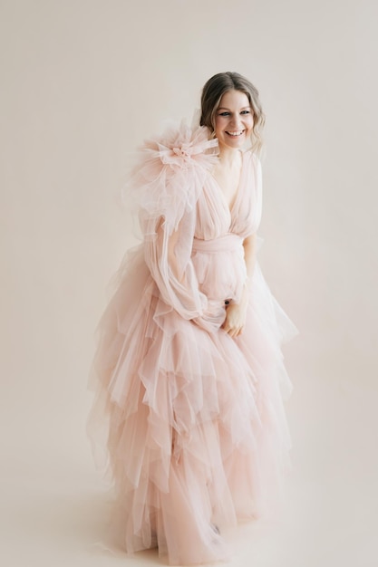 Pregnancy photo session at studio Pregnant woman blush pink royal queen fluffy dress High fashion