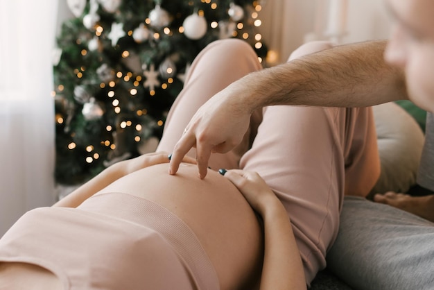 Pregnancy photo shoot men's hands on a woman's stomach