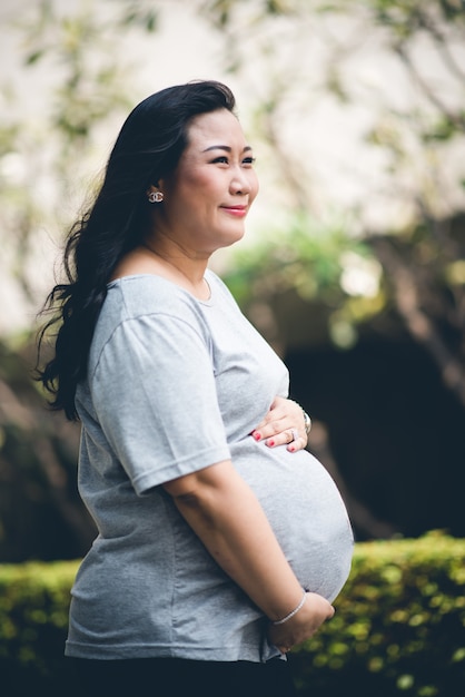 Беременная портретистка держится за животик в последний месяц перед родами