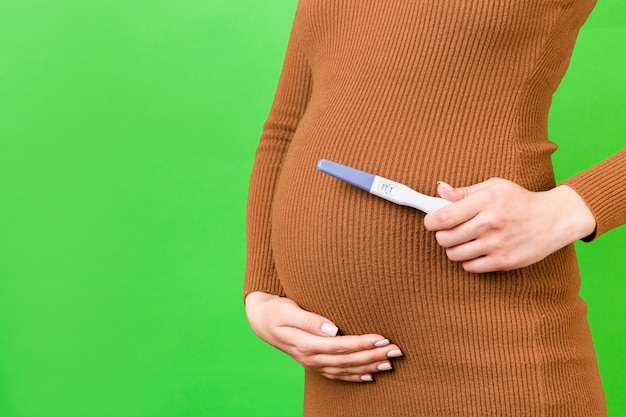 Pregnancy test against pregnant belly