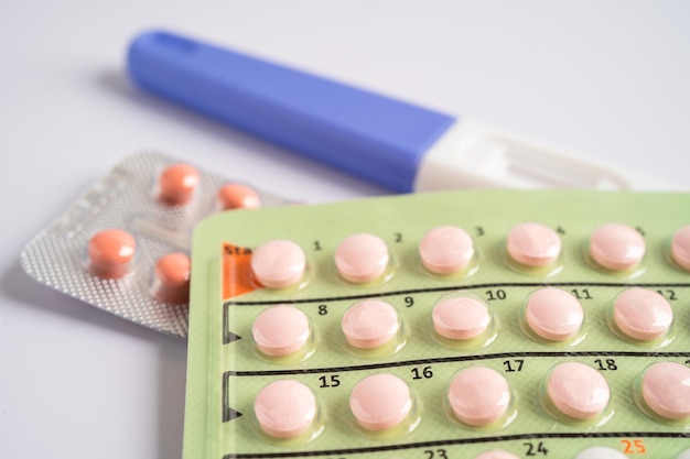 Pregnancy test and birth control pills on calendar contraception health and medicine