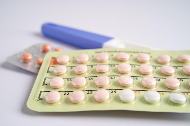 Pregnancy test and birth control pills on calendar contraception health and medicine