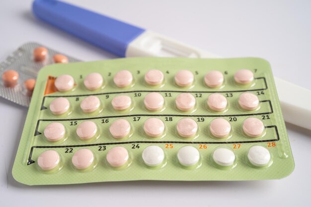 Photo pregnancy test and birth control pills on calendar contraception health and medicine
