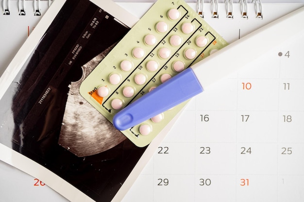 Photo pregnancy test and birth control pills with ultrasound scan of baby uterus contraception health and medicine