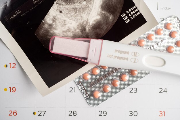 Photo pregnancy test and birth control pills with ultrasound scan of baby uterus contraception health and medicine
