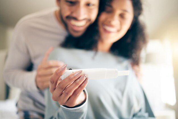 Pregnancy test hands of woman and happy couple smile and baby announcement together in home Pregnant person and new mother fertility and support for positive results and ivf success or news