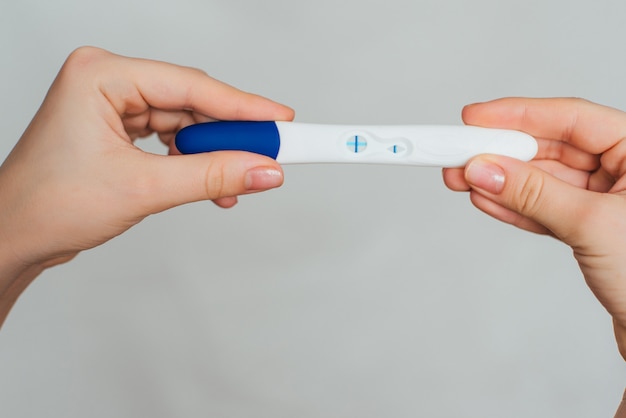 Pregnancy test in the hands of a woman with a positive result