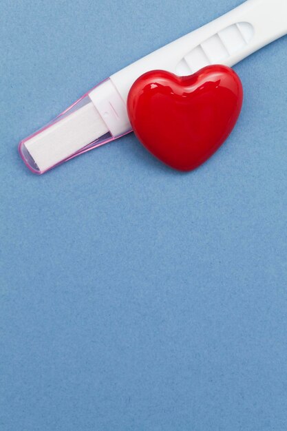 Pregnancy test with a red heart on a blue background