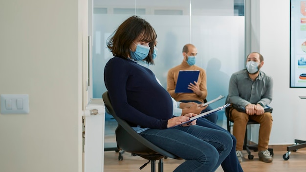 Pregnant applicant holding cv papers and preparing for job interview meeting with HR department. Career opportunity for woman expecting child, sitting in queue for recruitment.