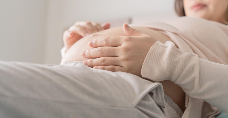 Photo 妊娠中のアジア人女性は腹に手を握り赤ちゃんに触れ自分の健康を心配しています美しい幸せな妊娠中の女性妊娠中の優しい気分の写真