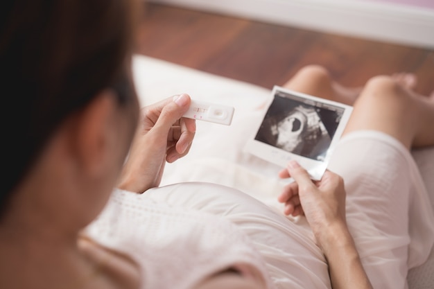 Беременная женщина Азии, глядя на ультразвуковое сканирование