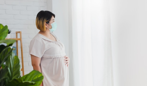 Photo pregnant asian women wear a protective mask to prevent germs